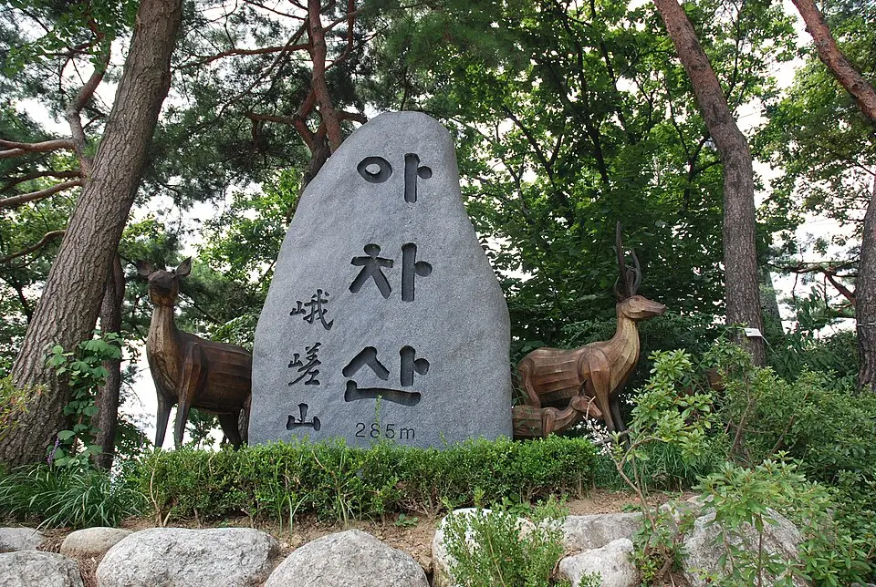 Achasan stone monument marker with Korean characters on forest hiking trail