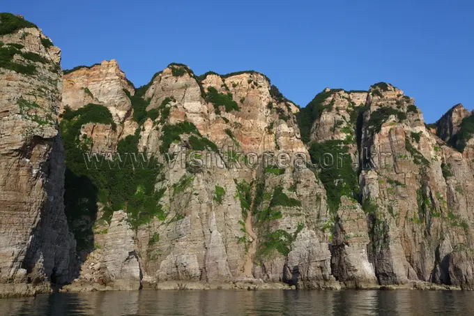 Towering coastal cliffs of Baengnyeongdo Island with vegetation