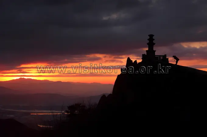 Silhouetted temple pagoda at Biseulsan Mountain during dramatic sunset