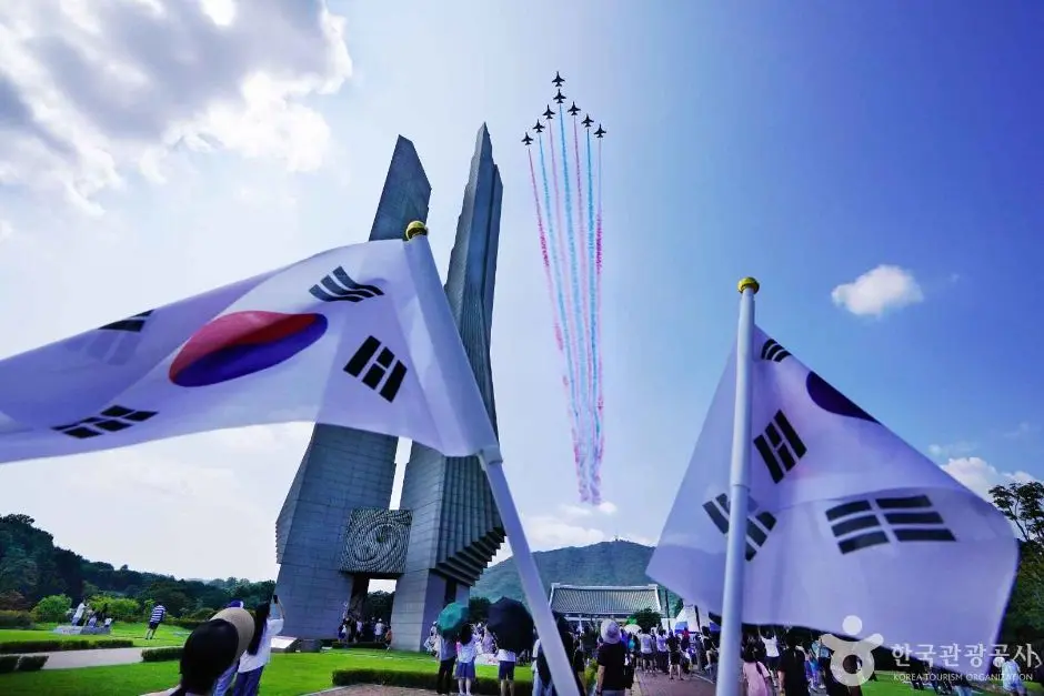 Black Eagles memorial monument with South Korean flags and fighter jets flying overhead