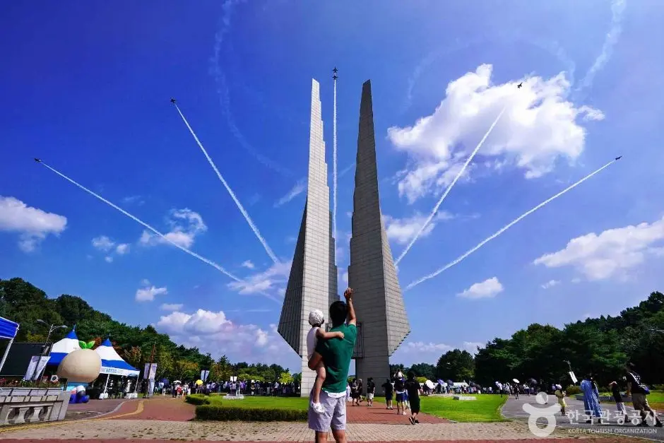 Black Eagles monument with aircraft contrails in blue sky