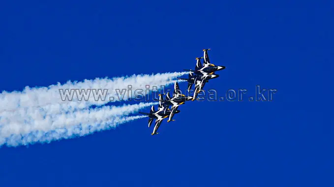 Black Eagles formation flying with smoke trails against blue sky