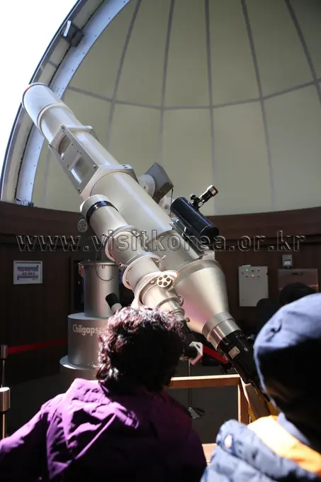 Visitors observing through large telescope at Chilgapsan Observatory