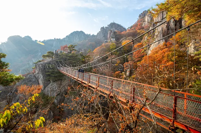 Daedunsan suspension bridge spanning dramatic mountain cliffs with autumn foliage