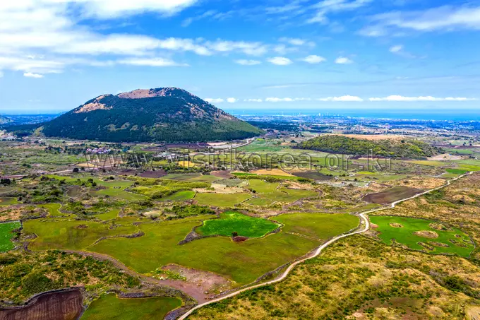 Aerial view of Darangshi Oreum cinder cone with surrounding green farmland
