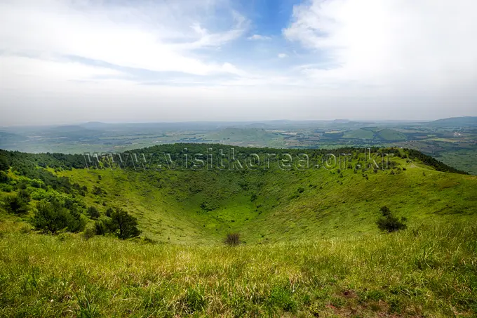 Darangshi Oreum crater rim with lush green slopes and distant valley