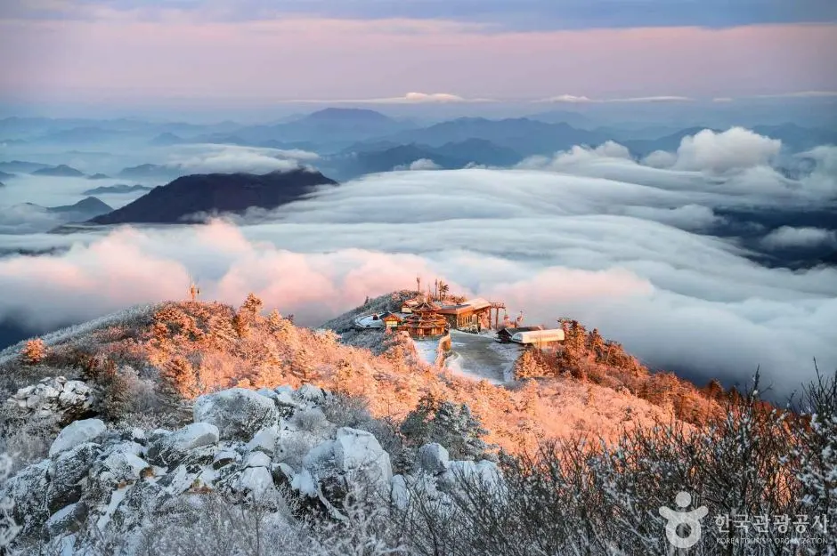 Snow-covered Deogyusan peak with sea of clouds and golden sunrise light