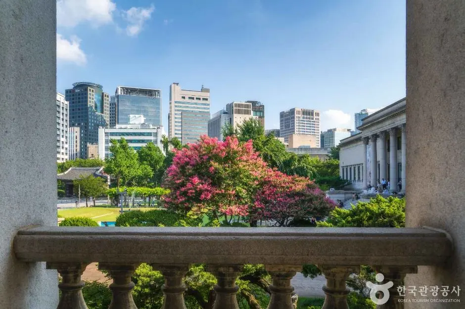 Deoksugung Palace garden view with blooming tree and Seoul skyline