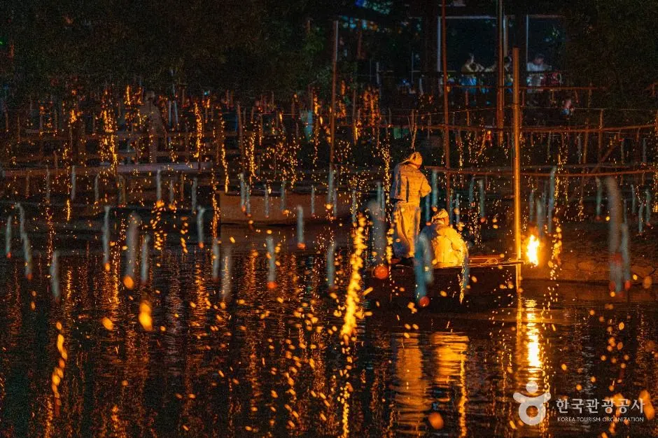 Nighttime Nakhwa Nori festival with illuminated falling flowers and fire displays