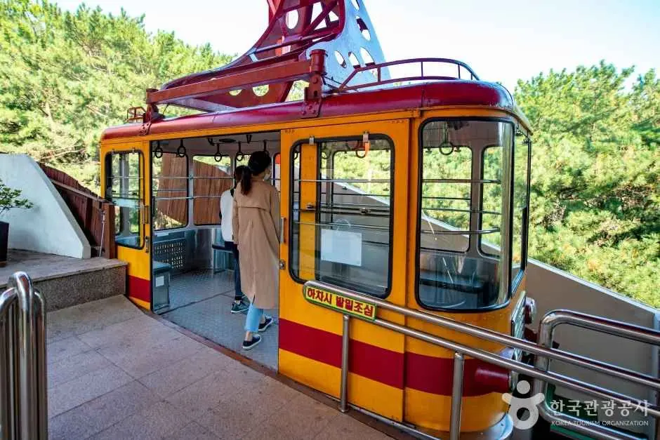 Yellow and red cable car station at Geumjeongsan with mountain forest views