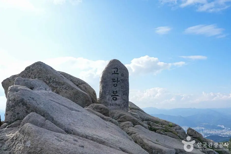 Summit marker stone at Geumjeongsan peak with panoramic mountain views