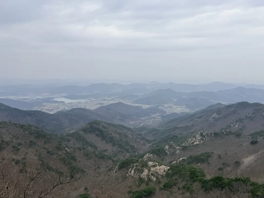 Panoramic mountain valley landscape with layered ridges and distant settlements at Gyeryongsan