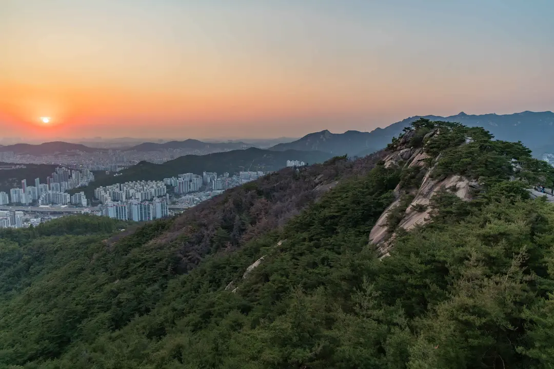 Inwangsan mountain at sunset with Seoul cityscape and golden hour sky