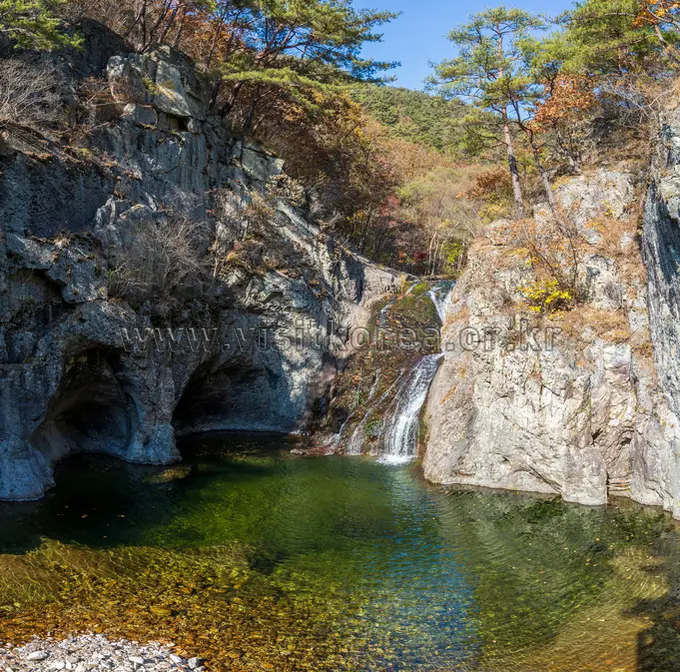 Juwangsan valley gorge with waterfall and turquoise pool surrounded by limestone cliffs