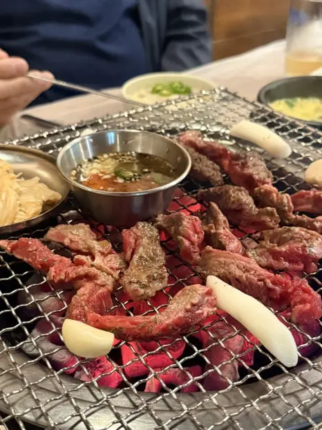 Grilled pork offal makchang sizzling on tabletop Korean BBQ grill