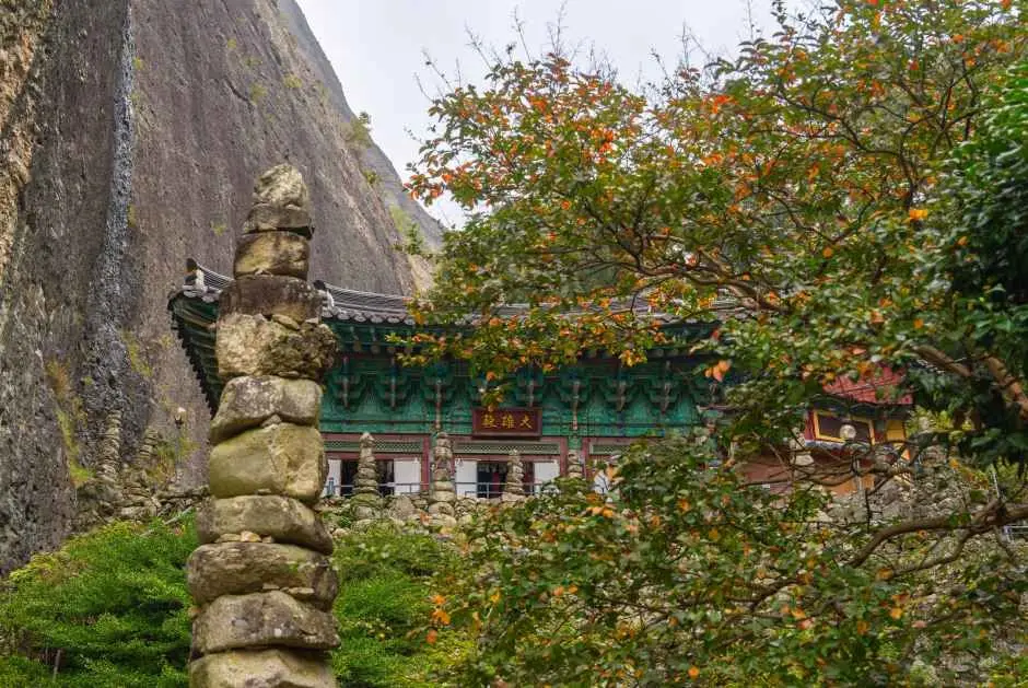 Stone pagodas at Tapsa Temple set against Maisan Mountain cliff
