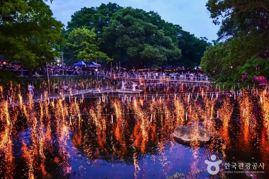 Thousands of lit torches reflected in water at Nakhwanori fire festival