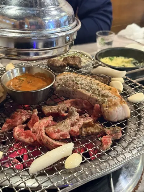 Korean makchang pork offal BBQ with dipping sauces and side dishes