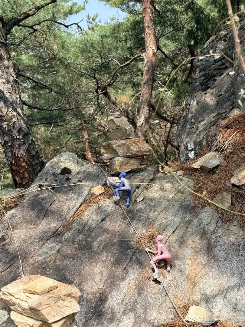 Rock climbers scaling granite boulders on Chaegyesan trail with ropes