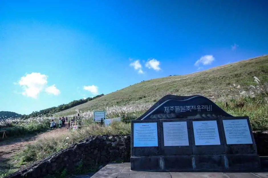 Informational signage and trail markers on Saebyeol Oreum hiking path