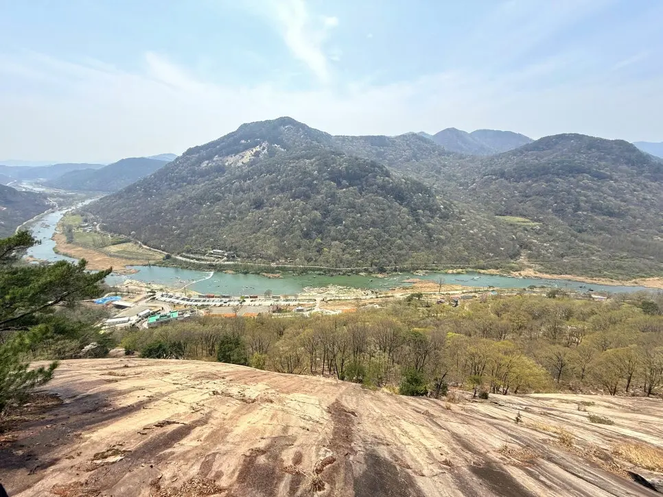 Panoramic view of Seomjingang River valley with forested mountains and turquoise waters