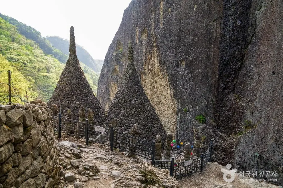 Ancient stone pagodas at Tapsa Temple set between dramatic rock cliffs